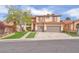 Charming two-story home featuring a red tile roof, three-car garage, and well-manicured front lawn at 1304 Autumn Wind Way, Henderson, NV 89052