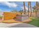 Backyard hot tub with wooden surround, palm trees, and artificial turf at 1304 Autumn Wind Way, Henderson, NV 89052