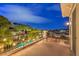 A serene balcony with wrought iron railing overlooks a pool and city lights, creating a relaxing outdoor living space at 1377 Ruby Sky Ct, Henderson, NV 89052