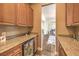 Convenient wet bar area with granite countertops, custom cabinetry, and a built-in wine refrigerator at 1377 Ruby Sky Ct, Henderson, NV 89052