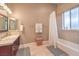 Neutral bathroom features a single vanity, bathtub, and elegant fixtures with soft lighting at 1377 Ruby Sky Ct, Henderson, NV 89052