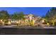 Beautifully landscaped two-story home with a well-manicured lawn and driveway at dusk at 1377 Ruby Sky Ct, Henderson, NV 89052