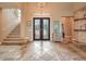 Elegant foyer boasts intricate tile flooring, a decorative front door, and a staircase leading to the upper level at 1377 Ruby Sky Ct, Henderson, NV 89052