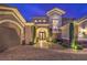 Elegant home entrance with stone accents, manicured shrubs, and a brick paver driveway at 1377 Ruby Sky Ct, Henderson, NV 89052