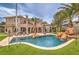 Back yard with home, pool, mature palms, waterfall feature and an expansive patio at 1377 Ruby Sky Ct, Henderson, NV 89052