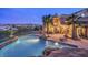 Backyard features a sparkling pool, desert landscaping, patio, and mountain views at 1377 Ruby Sky Ct, Henderson, NV 89052