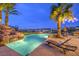 Inviting backyard pool with rock waterfall, palm trees, and stunning sunset views at 1377 Ruby Sky Ct, Henderson, NV 89052