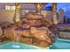Beautiful waterfall feature flowing into a sparkling pool, framed by palm trees at 1377 Ruby Sky Ct, Henderson, NV 89052