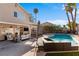 Inviting backyard features a sparkling pool, spa, and covered patio with comfortable seating under a blue sky at 1708 Crest Ave, Las Vegas, NV 89119