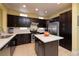 Kitchen features a kitchen island with dark cabinets, stainless appliances, and lots of counter space at 1908 Oliver Springs St, Henderson, NV 89052