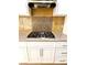 Close up of the kitchen cooktop with tile backsplash and stainless vent hood at 2200 S Fort Apache Rd # 2123, Las Vegas, NV 89117