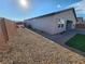 Wide-angle view of a backyard with gravel landscaping, a small patch of turf, and block wall at 247 Desoto Falls St, Indian Springs, NV 89018