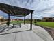 Community picnic area beneath a pergola, featuring grills and tables overlooking an open lawn at 247 Desoto Falls St, Indian Springs, NV 89018
