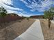 Neighborhood sidewalk featuring desert landscaping with young trees and shrubbery at 247 Desoto Falls St, Indian Springs, NV 89018