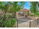 Back patio is surrounded by lush desert landscaping, mature trees, and an iron fence at 2714 Bridgepointe Dr, Las Vegas, NV 89121
