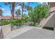 Private patio and lush desert landscaping enclosed by a decorative iron fence at 2714 Bridgepointe Dr, Las Vegas, NV 89121