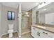 Well-lit bathroom features a shower with glass door, tiled walls, modern vanity, and fixtures at 2714 Bridgepointe Dr, Las Vegas, NV 89121