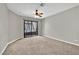 Large bedroom with a ceiling fan, carpet, and a sliding door for access to the outside at 2714 Bridgepointe Dr, Las Vegas, NV 89121