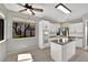 An open kitchen with white cabinets, a window with shade, stainless steel appliances, and a central island with cooktop at 2714 Bridgepointe Dr, Las Vegas, NV 89121
