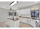 Bright kitchen featuring white cabinets, stainless steel appliances, and a central island with a cooktop and lots of light at 2714 Bridgepointe Dr, Las Vegas, NV 89121