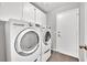 Convenient laundry room with front load washer and dryer and overhead cabinets for storage at 2714 Bridgepointe Dr, Las Vegas, NV 89121
