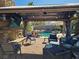 Covered patio featuring an outdoor television, ceiling fan, stone fireplace, and comfortable patio furniture at 2750 Sandalwood Ave, Henderson, NV 89074