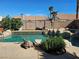 Backyard pool featuring custom rock features, beautiful landscaping, and clear blue skies, perfect for summer at 2750 Sandalwood Ave, Henderson, NV 89074
