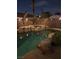 Backyard swimming pool at night, beautifully illuminated with custom rock features and privacy walls at 2750 Sandalwood Ave, Henderson, NV 89074