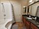 Bathroom with tub shower, wood vanity and granite countertops at 3145 E Flamingo Rd # 2005, Las Vegas, NV 89121