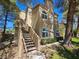 Two story condo featuring stairs leading up to entrance and well manicured lawn with mature trees at 3145 E Flamingo Rd # 2005, Las Vegas, NV 89121
