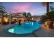 Beautiful backyard featuring a pool, spa, covered patio, outdoor kitchen, and lush tropical landscaping at 379 Fynn Valley Dr, Las Vegas, NV 89148