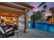 Inviting backyard with a pool, spa, covered patio, ceiling fan, outdoor seating, and well-manicured landscaping at 379 Fynn Valley Dr, Las Vegas, NV 89148