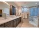 Modern bathroom featuring double vanities, marble accents, and a glass block window at 379 Fynn Valley Dr, Las Vegas, NV 89148