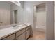 Clean bathroom with a single sink vanity, neutral cabinets, large mirror, and shower-tub combo at 379 Fynn Valley Dr, Las Vegas, NV 89148