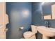 Stylish half bathroom with a modern sink, toilet, and dark blue painted walls at 379 Fynn Valley Dr, Las Vegas, NV 89148