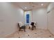 Bright bedroom with white walls, tile floors, and seating near the window at 379 Fynn Valley Dr, Las Vegas, NV 89148