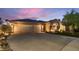 Home featuring a three-car garage, neutral stucco, stone accents, and landscaping at 379 Fynn Valley Dr, Las Vegas, NV 89148