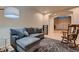 Comfortable seating area with a rocking chair, gray sofa, and tiled flooring leading to the front entry at 379 Fynn Valley Dr, Las Vegas, NV 89148