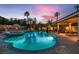 Expansive pool and spa with a Baja step, lush tropical landscaping, covered patio, and an outdoor kitchen at 379 Fynn Valley Dr, Las Vegas, NV 89148