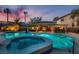 Stunning pool and spa area with tropical landscaping, a covered patio, and an outdoor bar for entertaining at 379 Fynn Valley Dr, Las Vegas, NV 89148