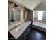 This luxurious bathroom features a long vanity with double sinks, a glass enclosed shelf, and a soaking tub at 4037 Chalfont Ct, Las Vegas, NV 89121
