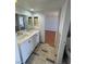 Bright bathroom featuring a double sink vanity, neutral tile flooring, and a separate toilet room at 4037 Chalfont Ct, Las Vegas, NV 89121