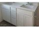 Bathroom vanity with double sinks, modern fixtures, and white cabinetry at 4145 Texas Lilac Ave, Las Vegas, NV 89139