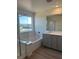 Primary bathroom features dual sinks, grey cabinets, and a separate tub and shower at 4153 Texas Lilac Ave, Las Vegas, NV 89139