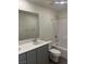 Bathroom with grey vanity, large mirror, and shower-tub combination at 4153 Texas Lilac Ave, Las Vegas, NV 89139