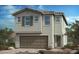 Charming two-story home with a neutral color palette, large garage door, and desert landscaping at 4153 Texas Lilac Ave, Las Vegas, NV 89139