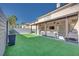 Spacious backyard featuring an outdoor seating area, grill, and manicured artificial grass at 4211 Saxton Green Ave, Las Vegas, NV 89141