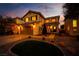 Charming two-story home with a well-manicured lawn and inviting curb appeal at dusk at 4211 Saxton Green Ave, Las Vegas, NV 89141