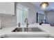 Modern kitchen with stainless steel sink, marble countertops, and tile backsplash with neutral tones at 4211 Saxton Green Ave, Las Vegas, NV 89141