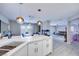 Open-concept kitchen with stone countertops, white cabinetry, and convenient access to the dining and living areas at 4211 Saxton Green Ave, Las Vegas, NV 89141